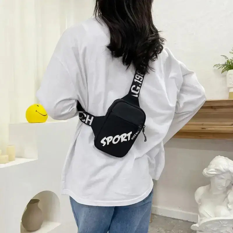 Person wearing a stylish black sling bag with 'SPORT' text, showcasing casual streetwear look.